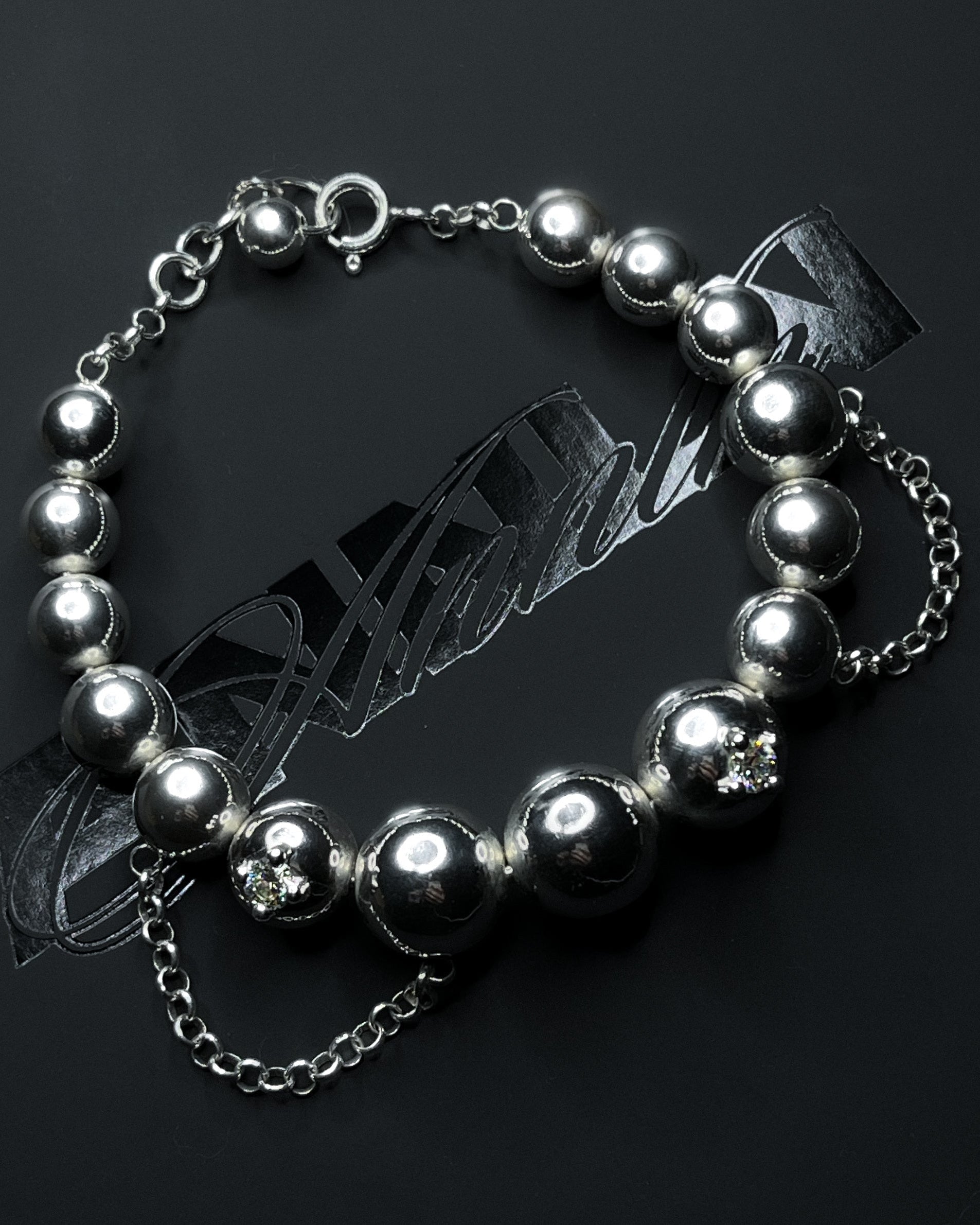 Silver beaded bracelet on a dark background