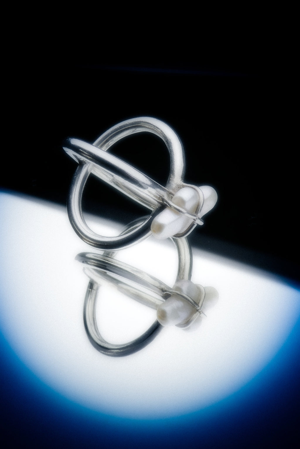 Silver ring with a unique design on a reflective surface