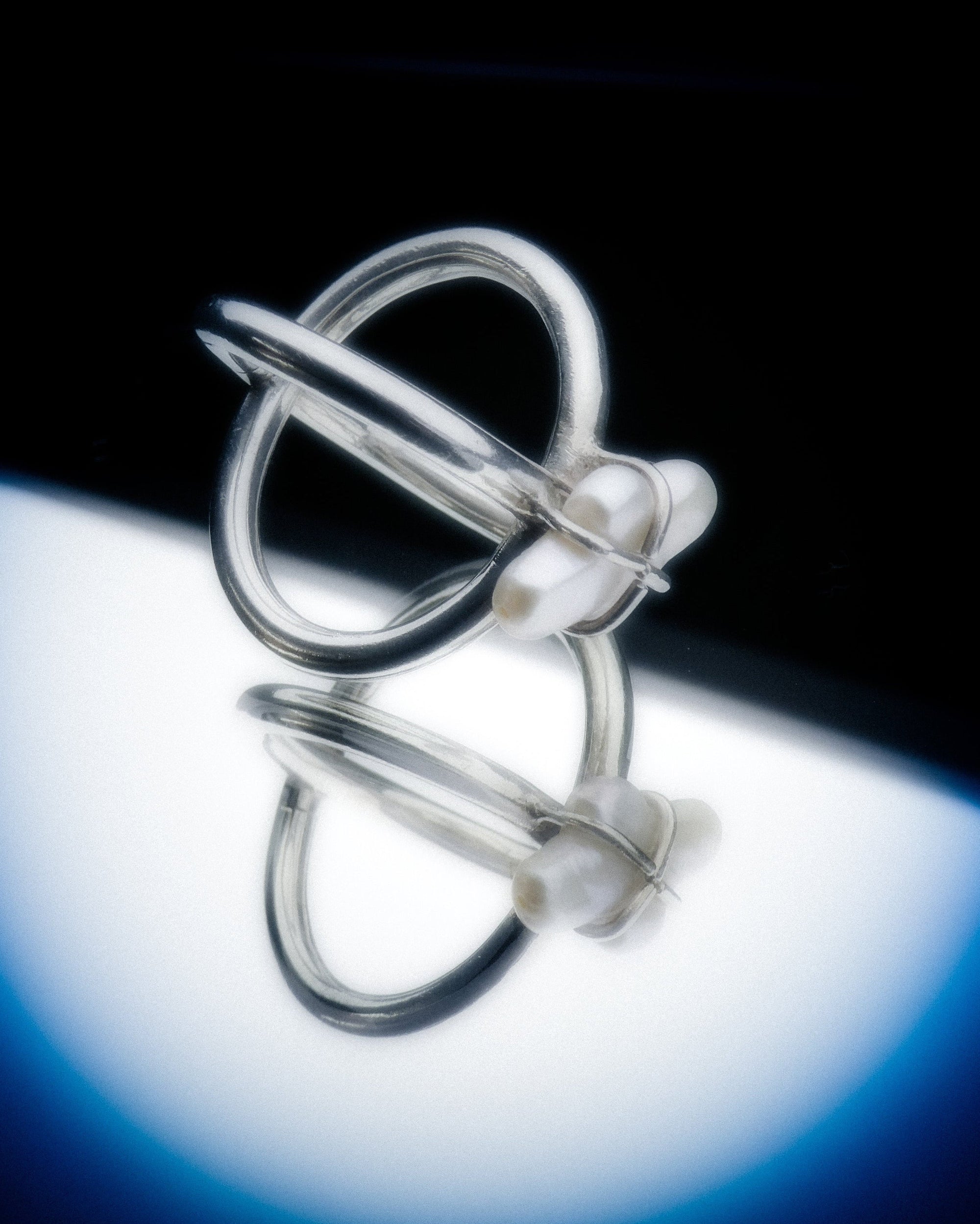 Silver ring with a unique design on a reflective surface