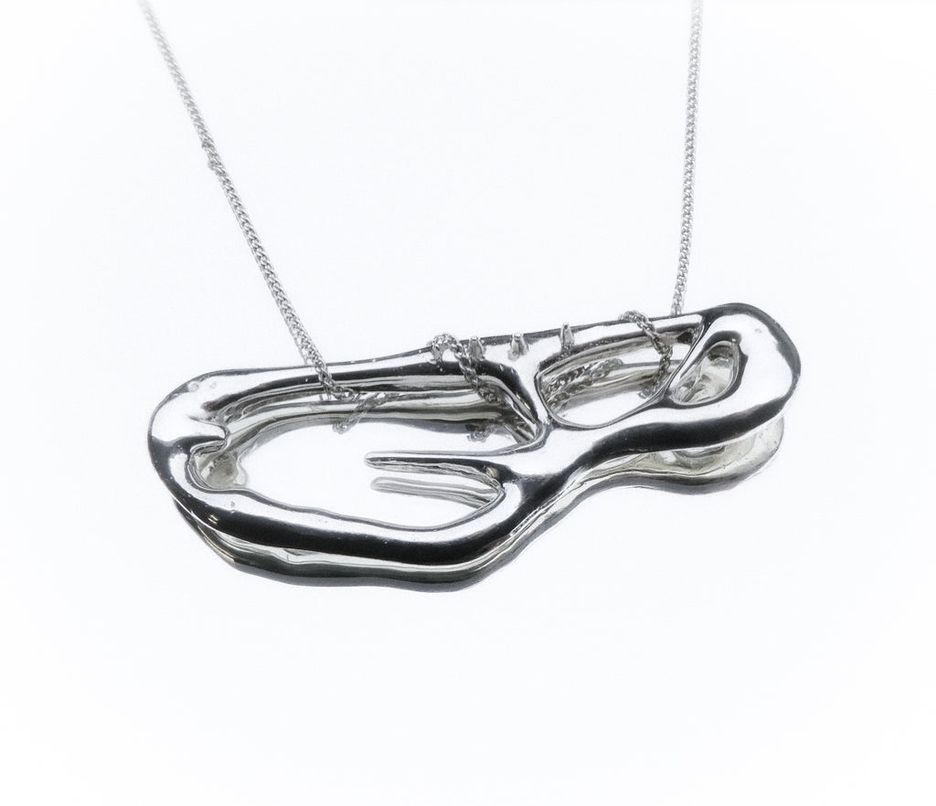 Silver necklace with a unique pendant on a white background monumental liquid shape