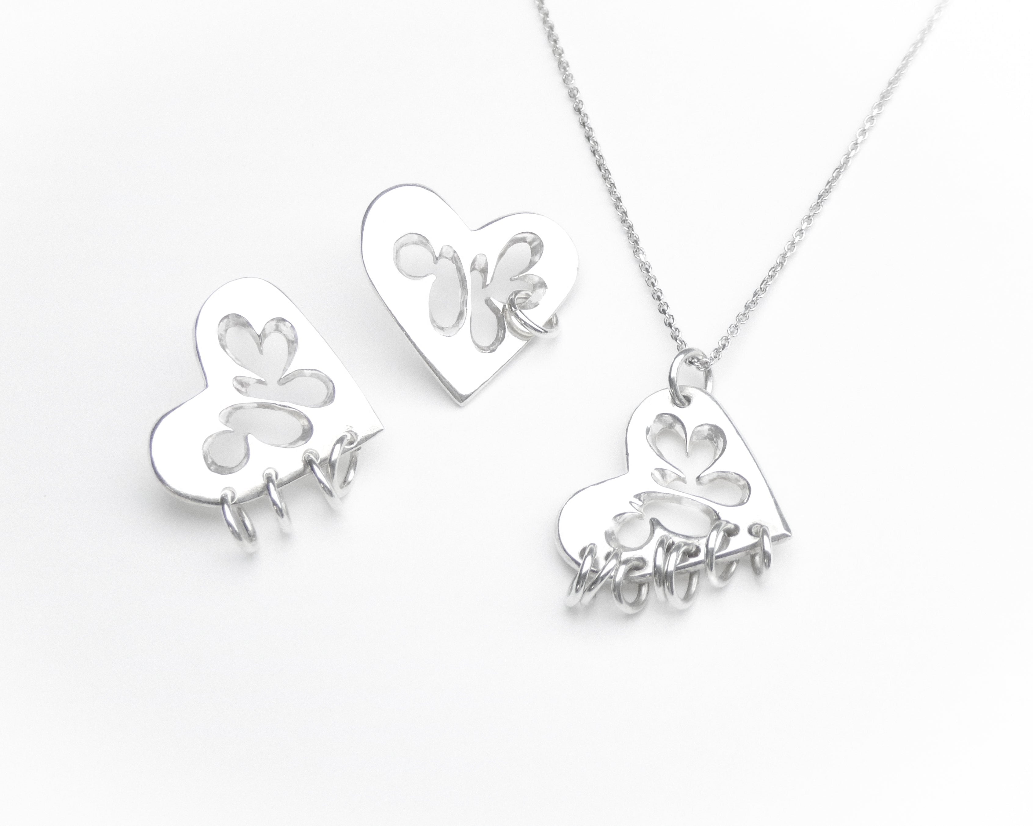 Silver heart shaped pendant and earrings with piercing style
